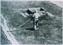 着塩した砂の塊を小さく壊していく均し