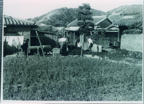 水道管の工事を見守るおばさん