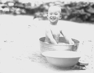 金ダライで水浴びをする子供